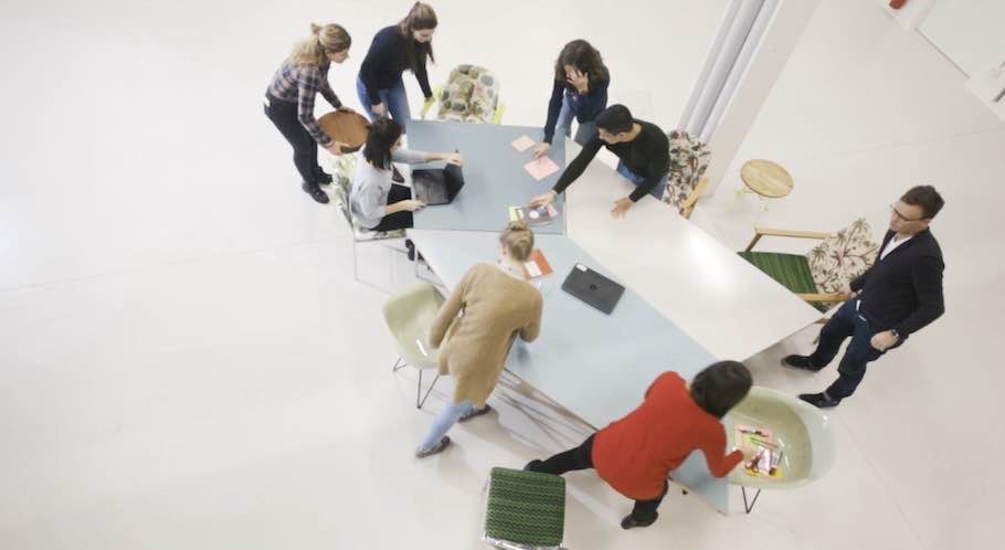 Team bei der Zusammenarbeit an einem großen Tisch, von oben fotografiert